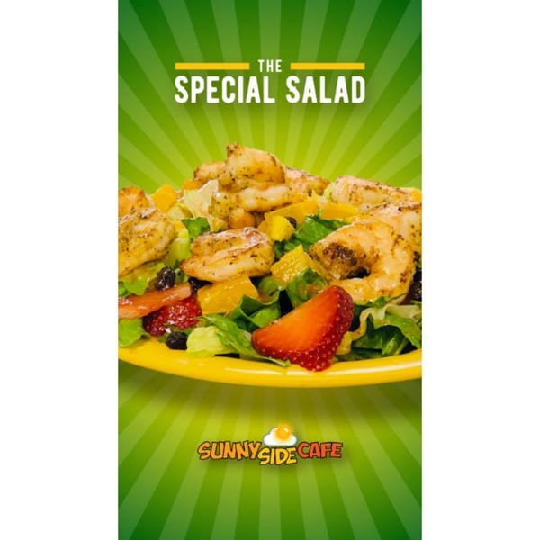 Sunnyside Cafe's Special Salad with grilled shrimp, strawberries, and mango on a yellow plate.