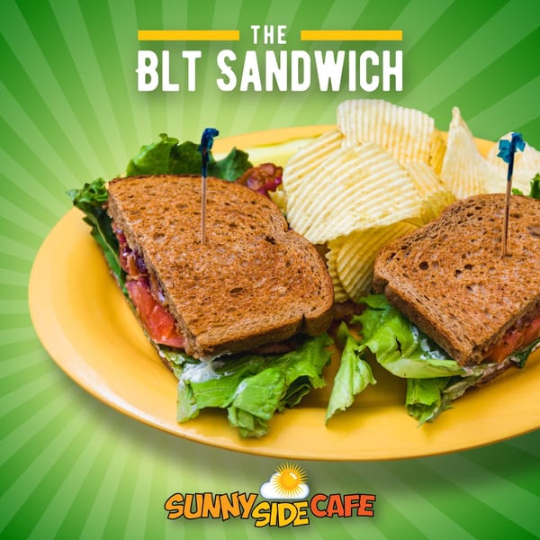 A Sunnyside Cafe BLT sandwich with crispy bacon, lettuce, tomato, and chips on a yellow plate.