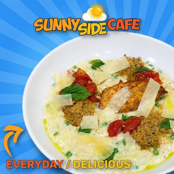 Creamy risotto with crispy chicken, parmesan, roasted tomatoes, basil, and breadcrumbs in a white bowl.