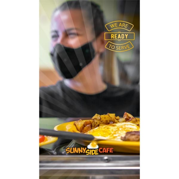 Sunnyside Cafe breakfast plate with eggs and potatoes, held by a masked server.