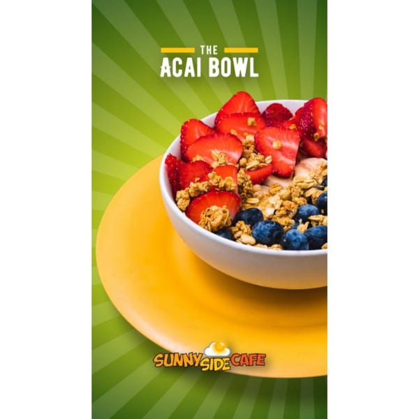 A Sunnyside Cafe acai bowl with strawberries, blueberries, and granola on a yellow plate.